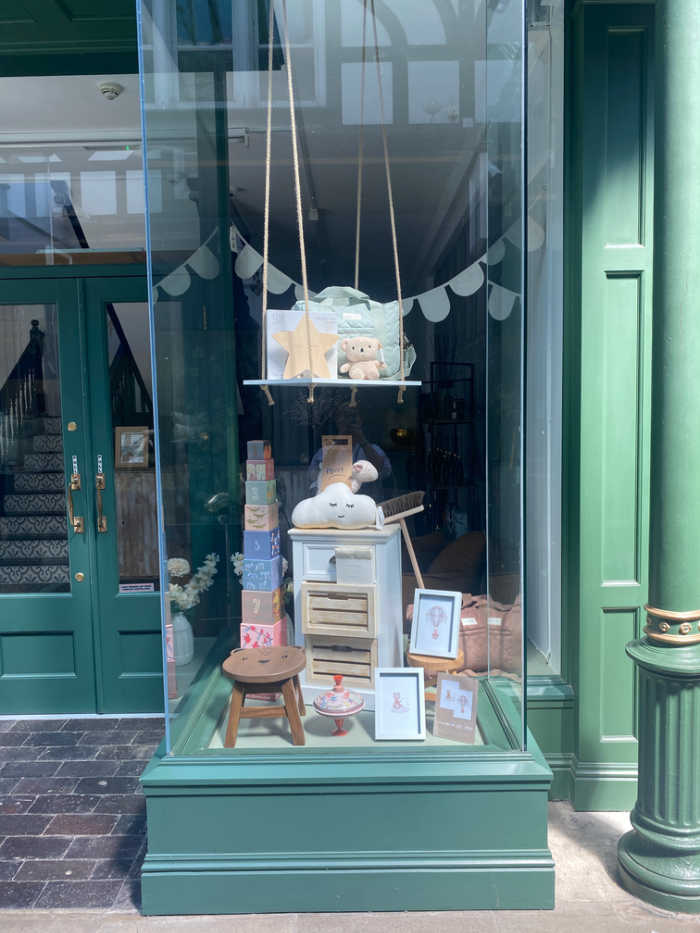 Shop window with baby accessories, cupboard, stool, spinning top