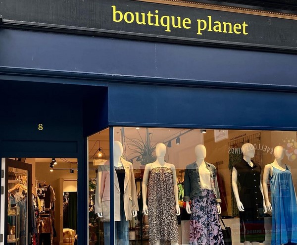 Planet Boutique shopfront in navy blue with yellow writing and mannequins in the window