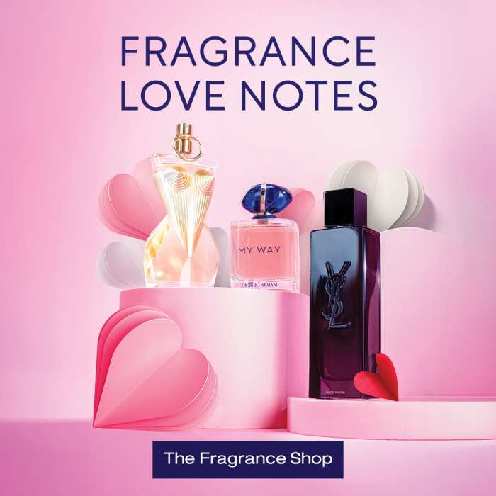 Perfumes bottles on a pink background surrounded by paper hearts
