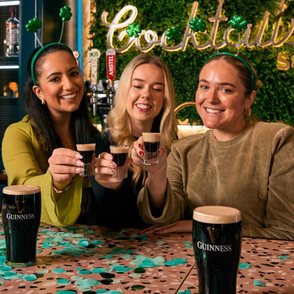 Three ladies drinking Guinness for St Patrick's Day