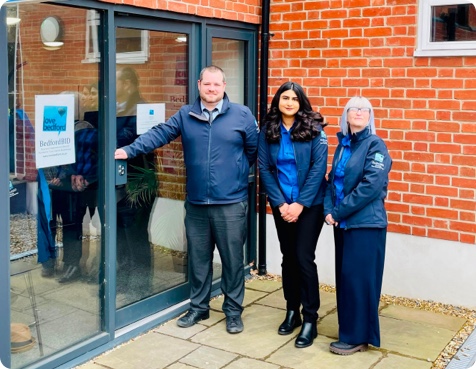 Shanice, Dan and Ilona in blue uniforms outside the BID office