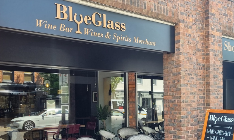 Blue Glass shop front with outdoor seating and blackboard