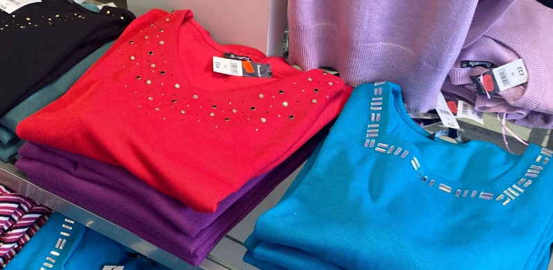 Bonmarche womens sweaters in red, purple and aqua, folded on a table
