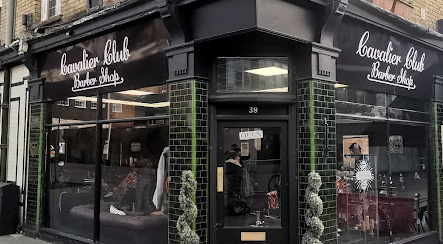 Cavalier Club shopfront with dark green tiling, topiary trees and black and white signage