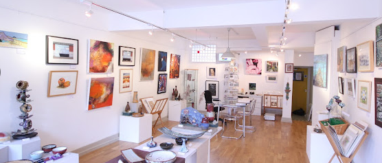 Eagle Gallery interior with paintings and display tables of pottery and jewellery
