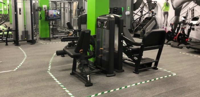 Energie Fitness gym various machines with white walls and black and green highlights