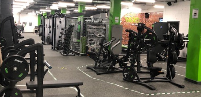 Energie Fitness gym various machines with white walls and black and green highlights