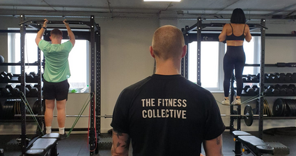Fitness Collective trainer supervising customers using equipment
