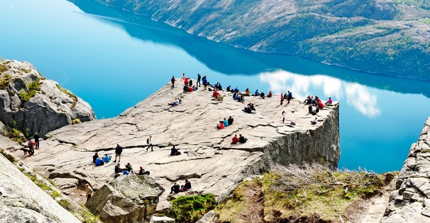 Hays visitors to fjords sitting on a large rock overlooking the water