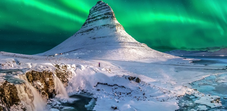 Hays snowy mountain landscape with green northern lights