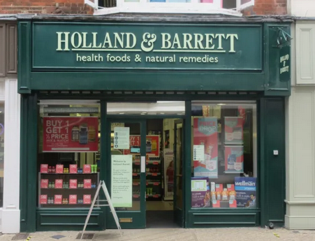 Holland & Barrett Bedford shopfront with cream writing on forest green