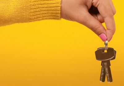 Hand with keys, yellow jumper and yellow background