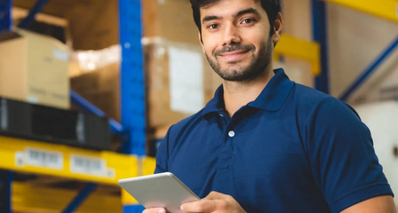 MEM smiling man with tablet in a warehouse
