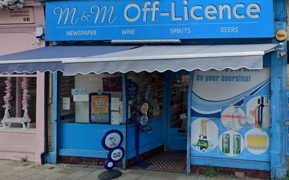 M&M Off-Licence shopfront with white writing on sky blue background