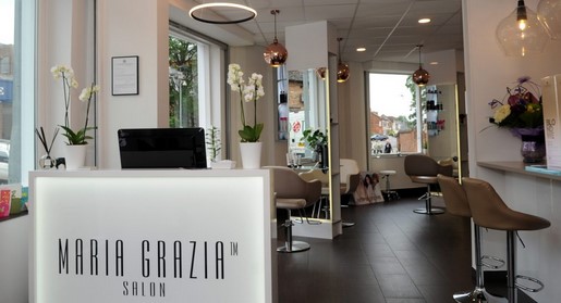 Maria Grazia ultra modern salon showing white reception desk, hairdressing stations