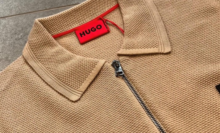 A beige polo shirt with a red label saying HUGO