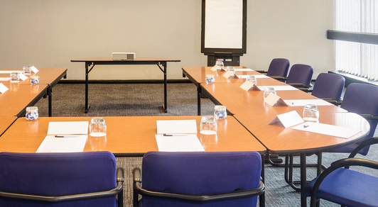 Mercure Hotel meeting room with timber desks and purple fabric chairs