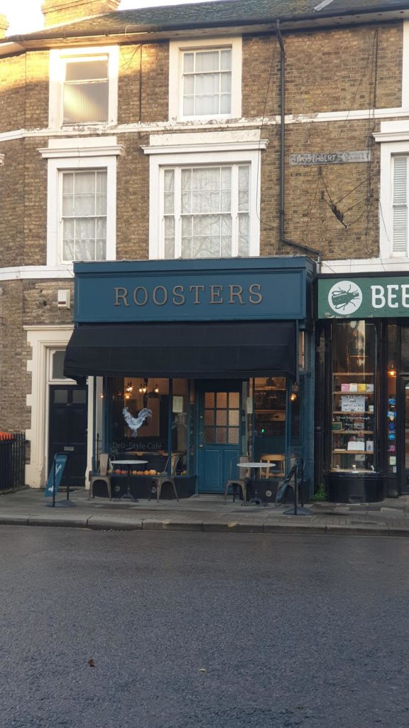 Roosters shop front with gold writing on teal boarding