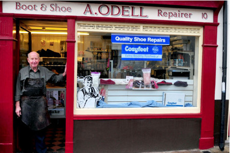 Odell shoes shopfront with owner in doorway