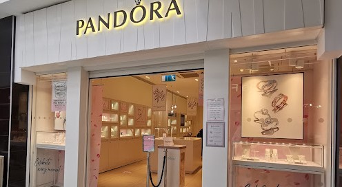 Pandora shopfront, cream frontage with glass windows showing cream and pink interior with jewellery in display cabinets