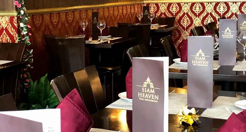 Siam Heaven tables set with burgundy and gold and matching wall covering