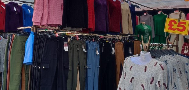 A market stall showing combat trousers in different colours all lined up.