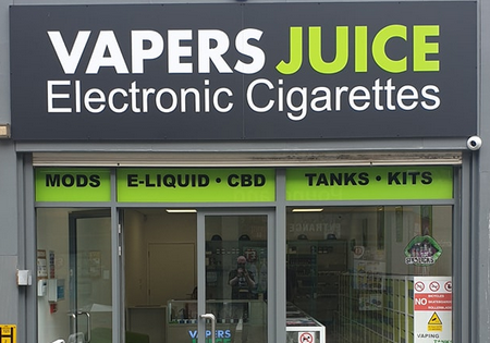Vapers Juice shopfront with green and white writing on a grey background