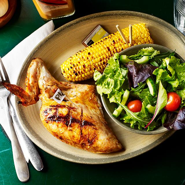 Nando's chargrilled chicken thigh, corn on the cob and salad.