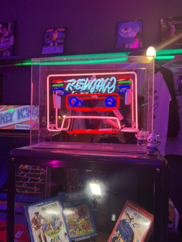 Rewind Arcade neon logo on shelf