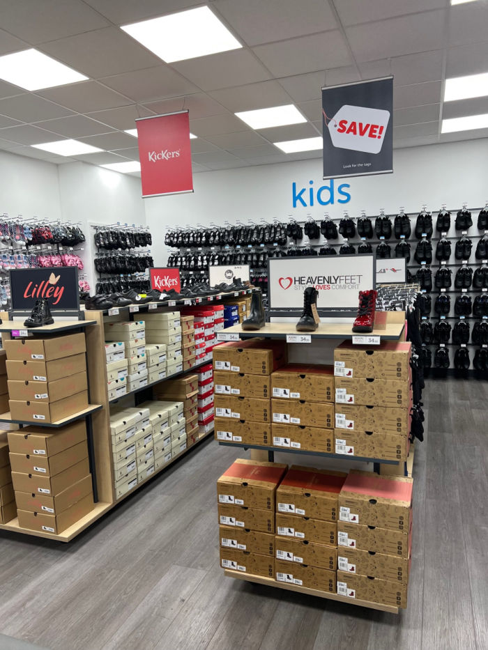 Free standing shelving footwear displayed on top shelf, shoe boxes underneath with a variety of sizes