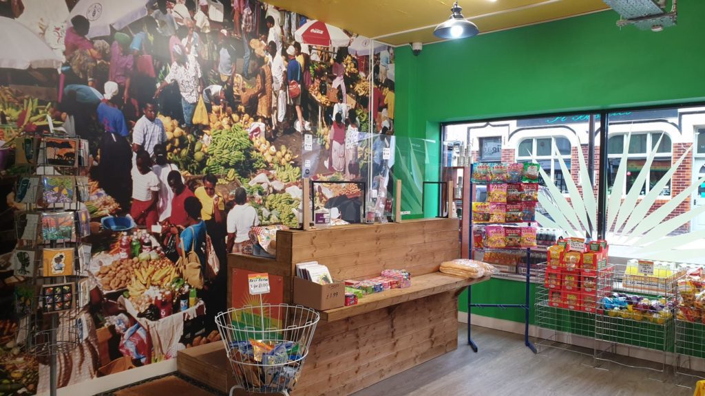 Montego's front counter with large image of Caribbean market on the wall