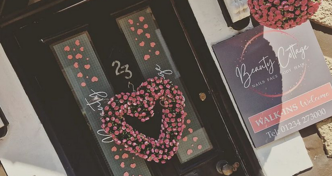 Beauty Cottage shopfront with pink floral decorations with pink and white branding