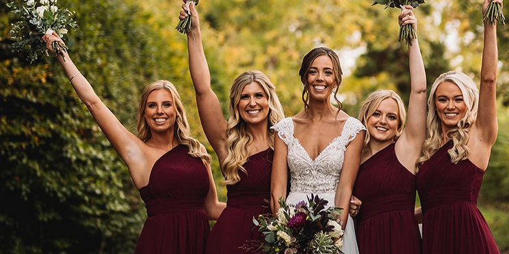 Krisp bride with bridesmaids wearing wine coloured one-shouldered bridesmaids dresses