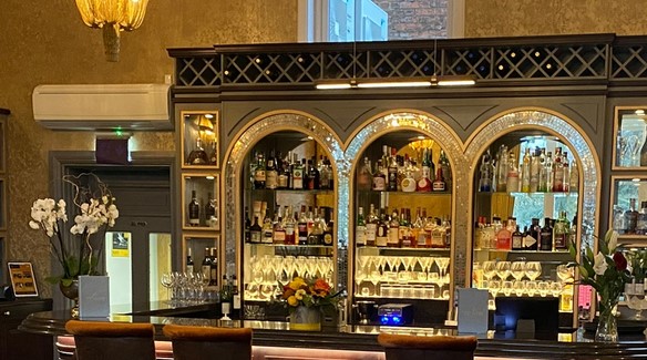 3 St Peters bar with golden lighting, showing shelves of spirits and mixers, glasses and menus