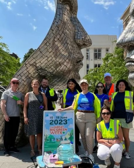 Staff, council members and directors in front of silver faces