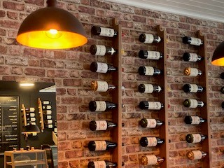 Maison de votre wine on wall in wooden holders