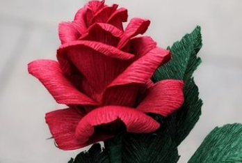 A red paper flower in the shape of a rose