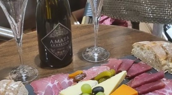 bottle of prosecco with cheese and a selection of cold cuts