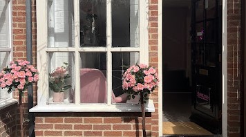 Bubblegum shopfront with artificial rose bushes at door