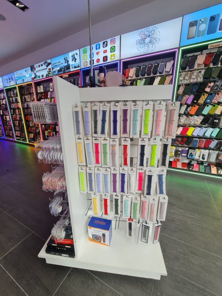 Straps for Apple watches in many different colours in front of a huge rack of phone cases.