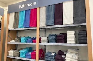 Edinburgh Woollen Mill coloured bath towels on shelves