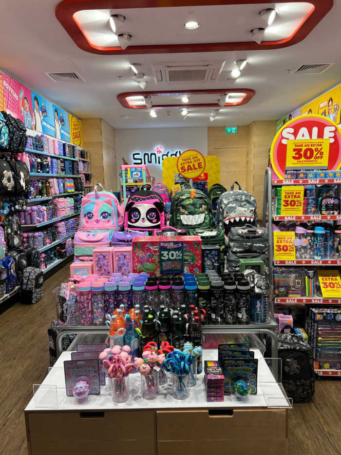 Smiggle interior shot, shelves of multicoloured products, stationery and backpacks