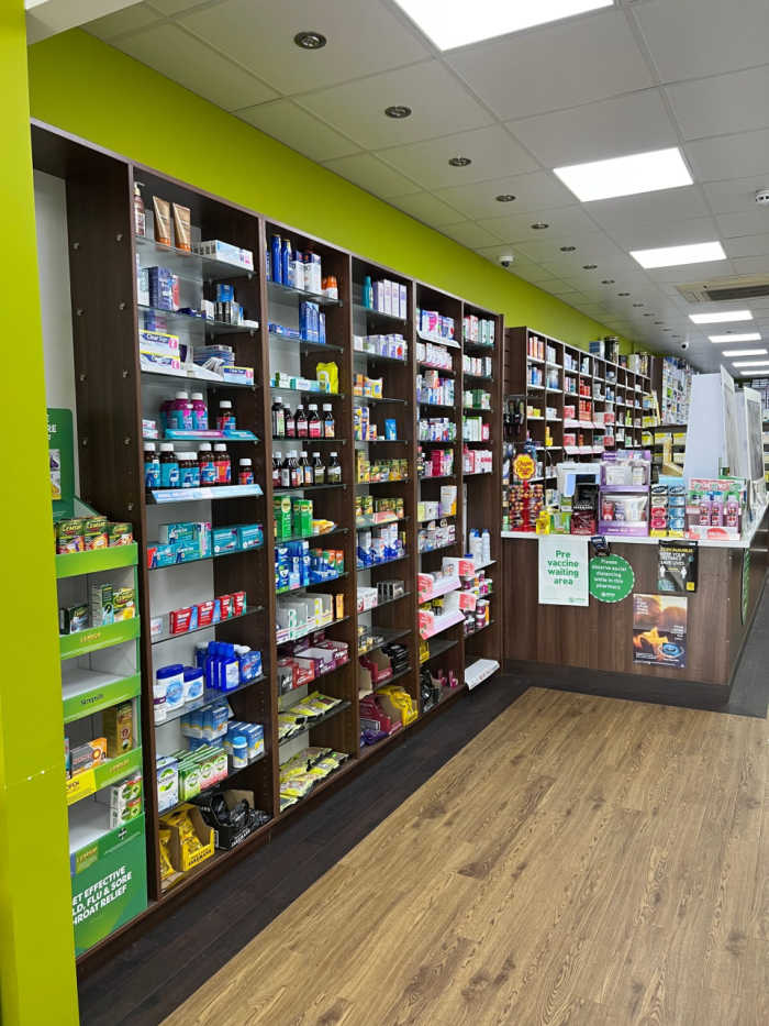 Store interior. Shelving containing a large variety of products on the left wall leading up to the main counter.