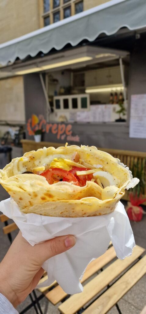 Image of a crepe in front of the It's Crepe O'clock van