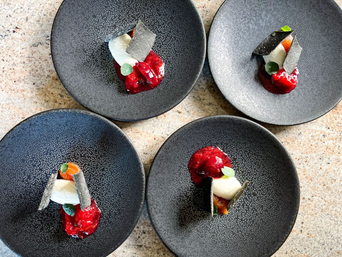 Four grey plates with a selection of starters